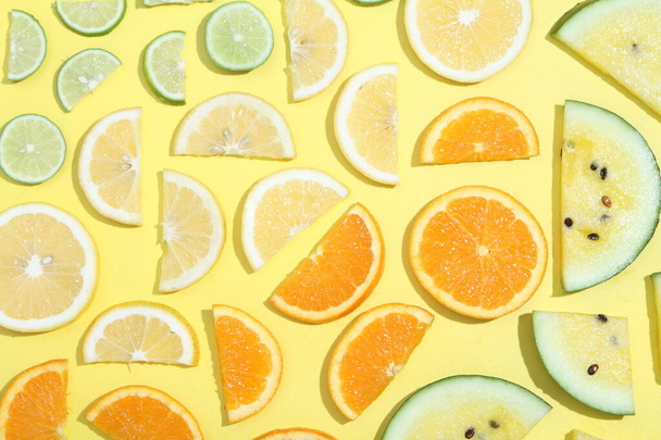żółte tło z plastrami pomarańczy i limonek - Zdjęcie, obraz