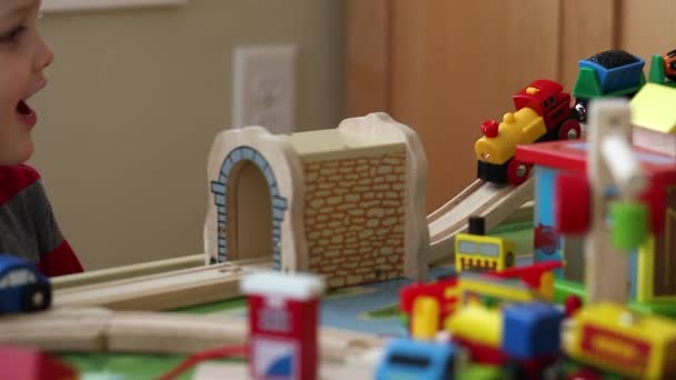 Boy plays with a toy train - Materiał filmowy, wideo
