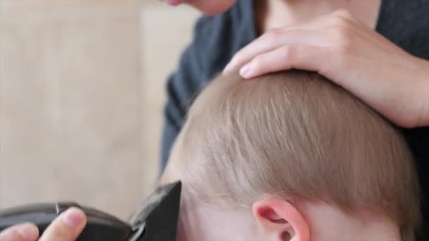 Nainen leikkaa taaperon hiuksia
 - Materiaali, video