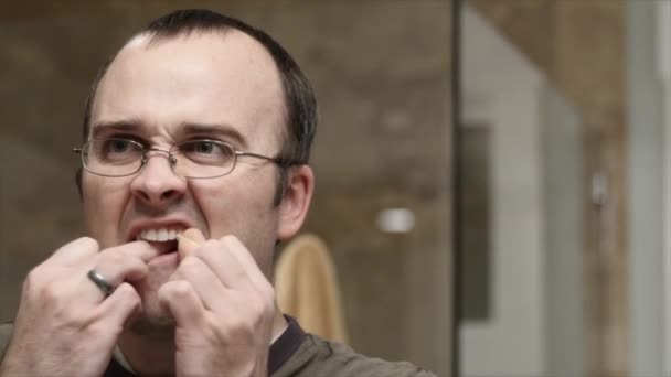 Man flossing his teeth - Filmati, video