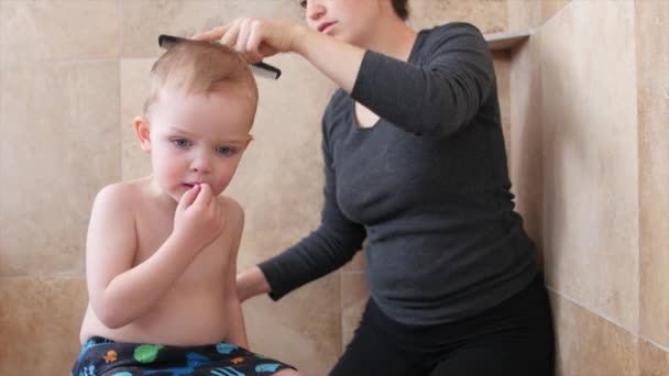 Γυναίκα κόβει τα μαλλιά της ένα μικρό παιδί - Πλάνα, βίντεο