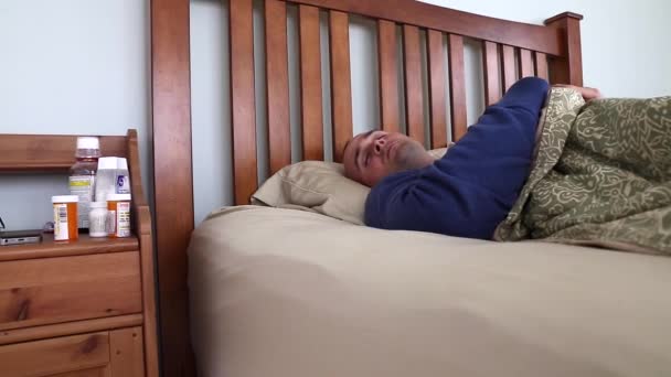 Sick man lying in his bed - Záběry, video