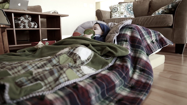 poika, jolla on flunssa makaa lattialla
 - Materiaali, video