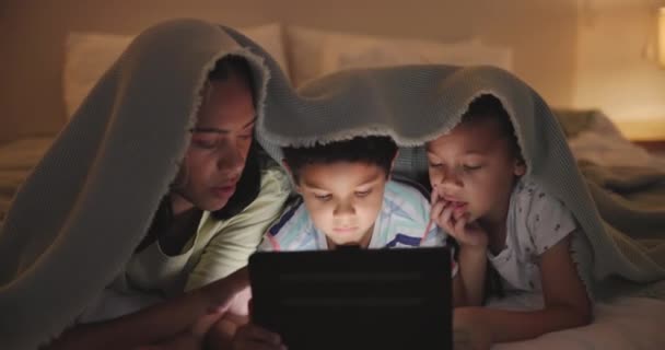 Anne, çocuklar ve tablet geceleri, evde ve internetteki oyunlar için battaniyeyle bağlanıyorlar. Kadın, kardeş ve bakım kapalı alanda dokunmatik ekran, eğlence ve abonelik ile çizgi film için teknoloji. - Video, Çekim