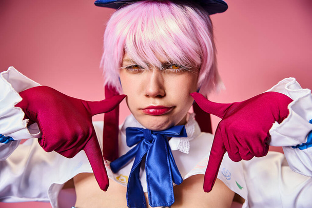 good looking sexy woman with red gloves and blue hat showing crying gesture on pink backdrop - Фото, изображение