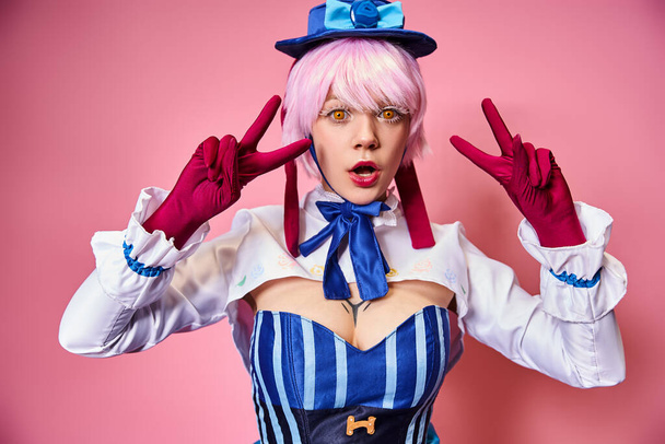 surprised young woman cosplaying anime character and showing peace gesture and looking at camera - Foto, afbeelding