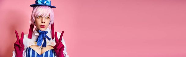 bájos szexi nő cosplaying anime karakter és bemutató béke gesztus rózsaszín háttér, banner - Fotó, kép