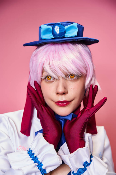 appealing fashionable woman cosplaying cute anime character and looking away on pink backdrop - Foto, imagen