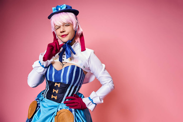 jolly appealing woman cosplaying vibrant anime character and looking at camera on pink backdrop - Foto, afbeelding