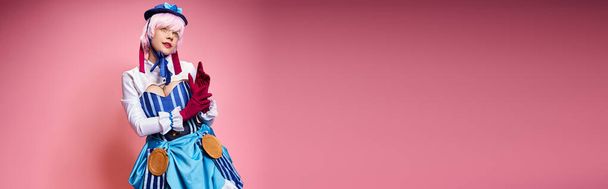 svůdná stylová žena cosplaying roztomilý anime charakter a odvrací pohled na růžové pozadí, banner - Fotografie, Obrázek