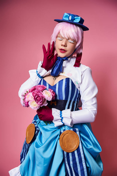 bonita mujer cosplaying lindo personaje de anime con flores rosas en las manos posando con los ojos cerrados - Foto, Imagen