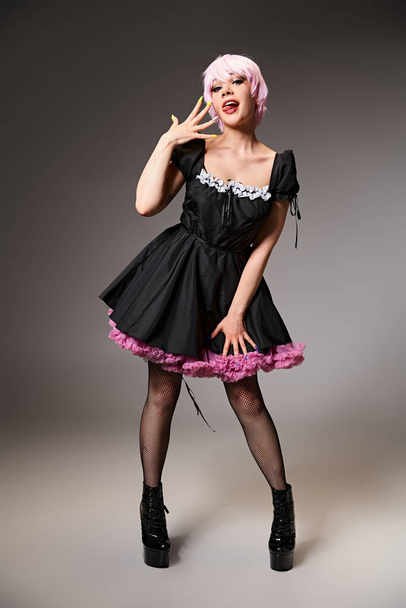 cheerful alluring female cosplayer in vibrant dress sticking out her tongue and looking at camera - 写真・画像