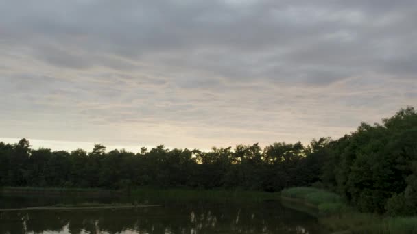 Questo suggestivo filmato di droni cattura i momenti sereni in un lago mentre si avvicina il tramonto. L'acqua è ferma, rispecchiando il cielo strutturato in alto, dove le nuvole formano un arazzo che allude all'arrivo - Filmati, video