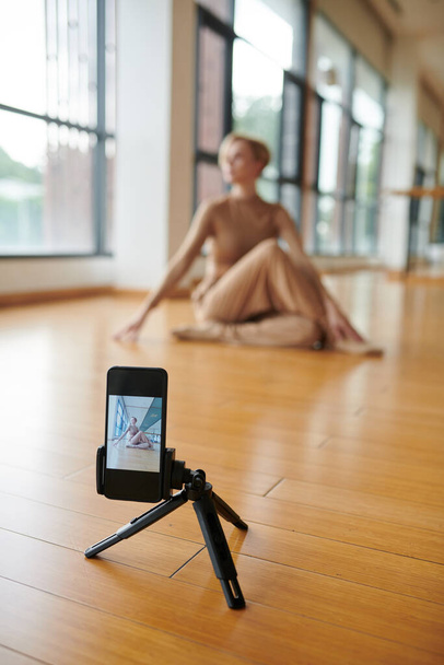 Femme danseuse installé smartphone sur monopode pour se filmer pratiquer une nouvelle danse - Photo, image