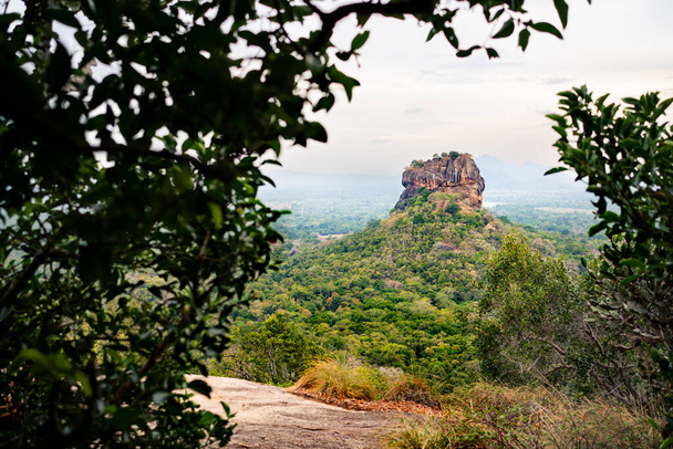 Sigiriya, Sri Lanka. Lion's Rock from Pidurangala mountain. Travel in Dambulla, Srilanka. Tourism in world heritage site. Green forest trekking and hiking in nature. Fortress, temple and monument. - Photo, Image