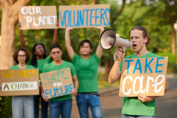 Grupa aktywistów zachęcająca innych do bycia wolontariuszami i dbania o przyrodę - Zdjęcie, obraz
