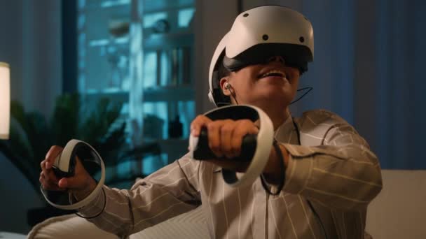 Metaverse verkennen virtual reality cyberspace wereld blij enthousiast Afro-Amerikaanse vrouw spel spelen meisje met 3D digitale technologie VR bril helm gaming controllers cyber gamer 's nachts thuis - Video