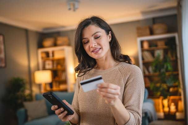 Eine erwachsene kaukasische Frau zu Hause glücklich lächeln halten Bank-Kreditkarte und digitale Tablette Online-Shopping E-Banking-Konzept echte Menschen kopieren Raum E-Commerce machen Kauf oder Buchung - Foto, Bild