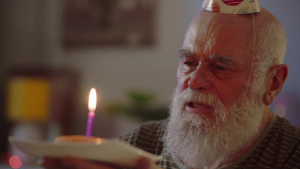 Vanha mies kotona juhlii syntymäpäiväänsä yksin. Kaikki unohtivat syntymäpäivän. Vanha sairas mies katsoo kakkua, toivoo jotain ja puhaltaa kynttilän. Laadukas 4k kuvamateriaalia - Materiaali, video