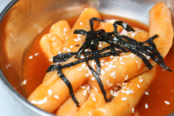 Close-up van Koreaans voedsel Topokki of Tteokbokki (roergebakken rijstcake) belegd met nori (zeewier) op een metalen schaal - Foto, afbeelding