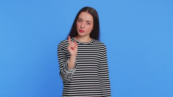 Quarrel. Displeased young woman gesturing hands with irritation and displeasure, blaming scolding for failure, asking why this happened. Brunette attractive girl isolated on blue studio background - Footage, Video