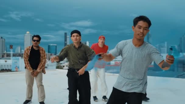 Egy csoport multikulturális hipszter, akik színjelzőt játszanak a tetőn. Vonzó utcai táncos kezében színes füst és végre break tánc lépés hip-hop zene. Kültéri sport 2024. Utcai tánc. hiphop. - Felvétel, videó
