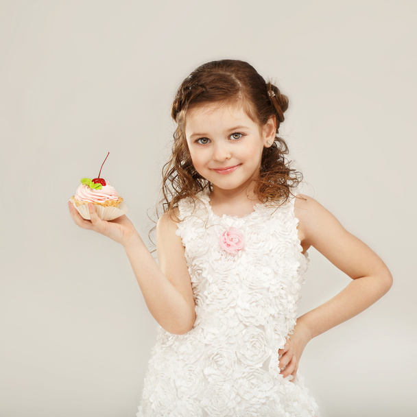 Κοριτσάκι που κρατάει ένα νόστιμο κέικ με κεράσι - Φωτογραφία, εικόνα