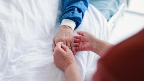 Ασθενής, πρόσωπο και κρατώντας τα χέρια στο κρεβάτι του νοσοκομείου ή φροντίζοντας για το πρόβλημα υγείας για ιατρική υποστήριξη, αγάπη ή ενσυναίσθηση. Άνθρωποι, δάχτυλα και αγκαλιάζουν την άνεση σε κλινική ή γάμο συμπόνια, πόνο ή ιό. - Πλάνα, βίντεο