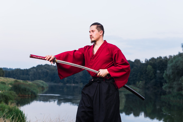 Hombre con traje japonés samurai étnico uniforme con espada katana
 - Foto, imagen