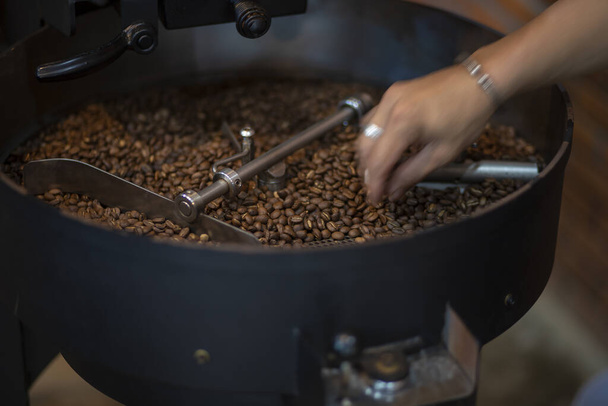 Kahvipavut paahtamisen aikana, liikkuvat meloa seulonta suppilon jäähdytys kahvipapuja paahtamisen jälkeen. Rumputyyppinen paahdin - Valokuva, kuva