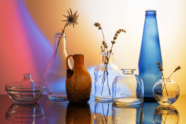Butelki szklane na kolorowym tle gradientowym - Zdjęcie, obraz