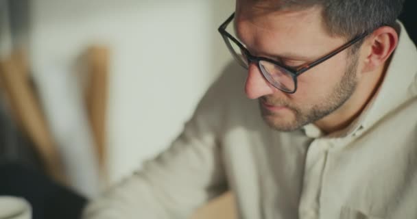 Giovane uomo d'affari professionale regolazione occhiali mentre si lavora in ufficio - Filmati, video