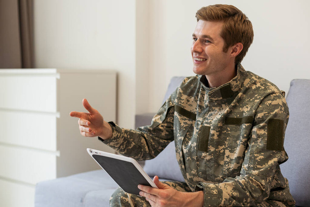 Jovem soldado feliz segurando um tablet de computador. - Foto, Imagem