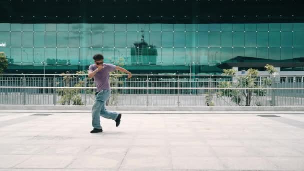 Aziatische hipster doen bevriezen pose terwijl kijken naar de camera op de stad. Panorama shot van professionele street dancer praktijk b-boy voetstap of break dance. Moderne levensstijl.Outdoor sport 2024. Schitterend.. - Video