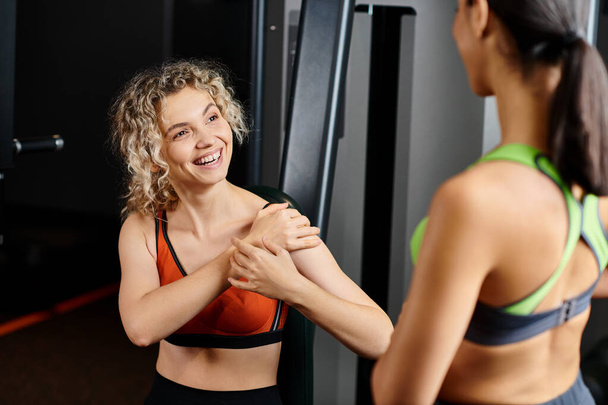 cheerful female coach explaining to her appealing jolly client how to use chest press machine - Φωτογραφία, εικόνα