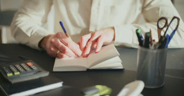 Порушення стратегії підготовки чоловіка-підприємця під час написання на блокноті за столом в офісі - Кадри, відео