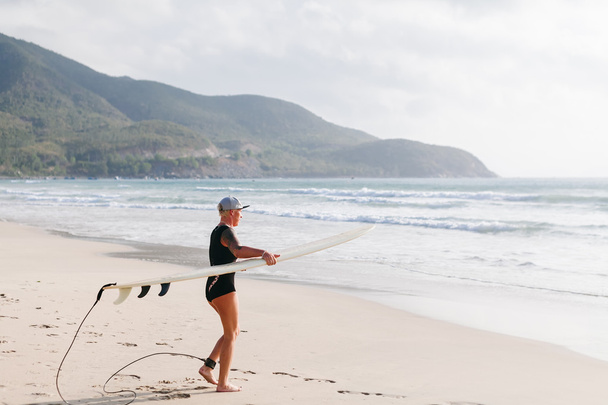 sörf tahtası kadınla sahilde sörf - Fotoğraf, Görsel