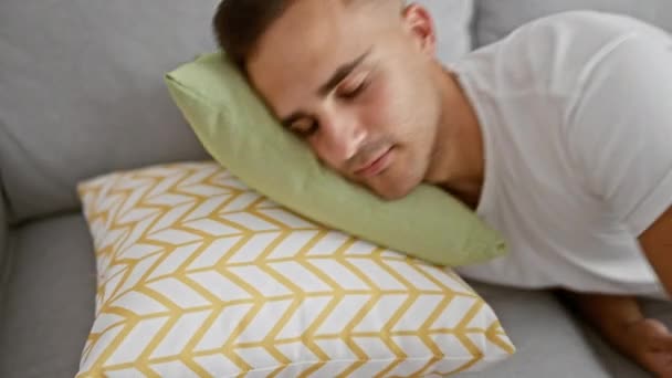 Jongeman die vredig slaapt op een geometrische kussen in een gezellige moderne woonkamer. - Video