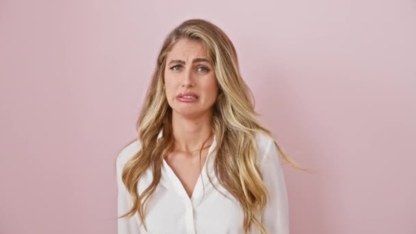 Jonge, angstige blonde vrouw in roze walgen bij afkeer - een aangenaam portret van ontevreden uitdrukking staande solo over geïsoleerde achtergrond - Video