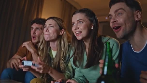 競争力のあるプレーヤーは夜遅くにアパートのソファーでビデオゲームを楽しんでいます. ビデオゲームをプレイするギャンブルの若者は,競争に勝つ. エキサイティングな友人は夜にホームソファーに座って勝利を喜びます. - 映像、動画
