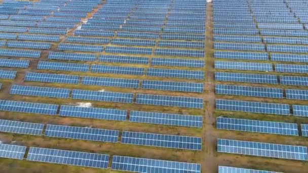 Вид с воздуха на большую электростанцию с большим количеством рядов солнечных фотоэлектрических панелей для производства чистой электроэнергии. Возобновляемые источники энергии с нулевыми выбросами - Кадры, видео