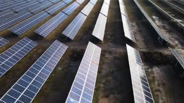 クリーンな電気を生産するために太陽光発電パネルの多くの列を持つ大規模な発電所の空中ビュー. 排出ゼロの再生可能エネルギー - 映像、動画