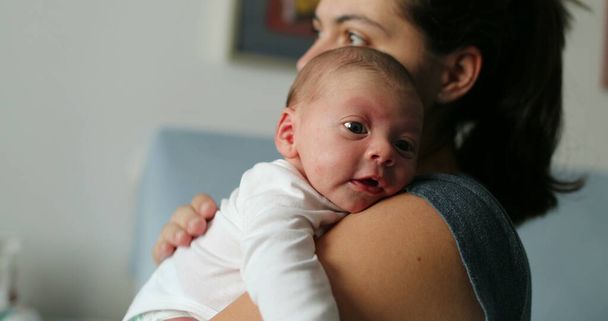 Мати натискає на новонароджену дитину, щоб допомогти з гикавками
 - Фото, зображення