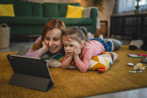 Matka i córka używają tabletu cyfrowego do oglądania wideo online w domu - Zdjęcie, obraz