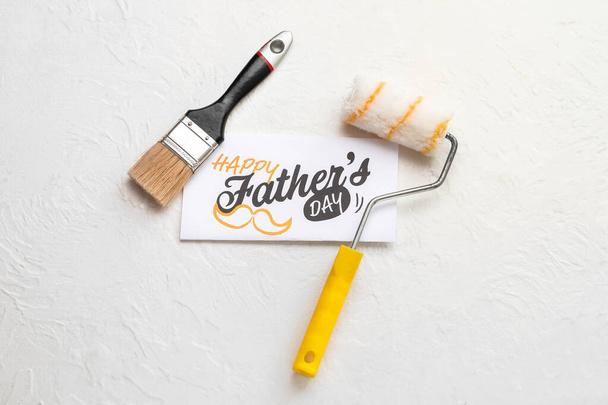 Carte pour la fête des pères avec rouleau de peinture et pinceau sur fond blanc - Photo, image