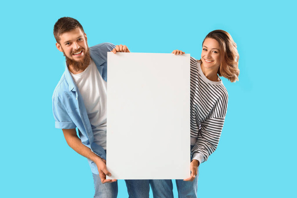 Ευτυχισμένο ζευγάρι ερωτευμένο με λευκή αφίσα σε μπλε φόντο - Φωτογραφία, εικόνα