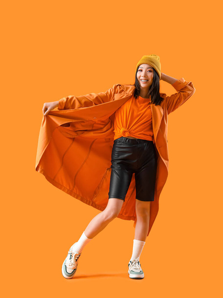 Elegante giovane donna asiatica su sfondo arancione - Foto, immagini