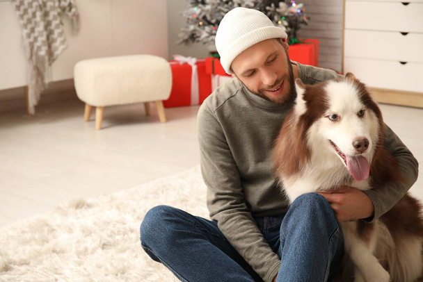 Bello giovane uomo con carino Husky cane a casa - Foto, immagini