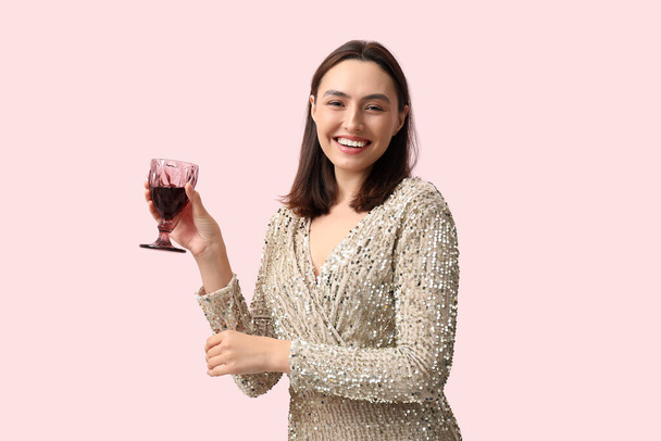 Mulher bonita com copo de vinho tinto no fundo rosa - Foto, Imagem