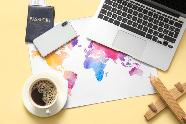 Composition with modern gadgets, world map, passport and cup of coffee on color background - Photo, Image